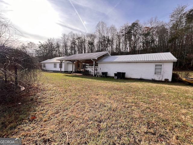 rear view of property with metal roof, a lawn, and cooling unit