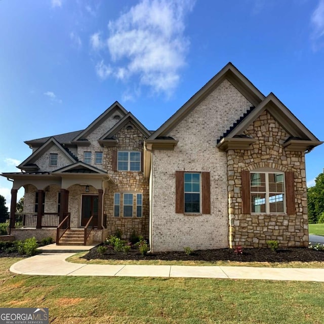 craftsman house featuring covered porch and a front yard