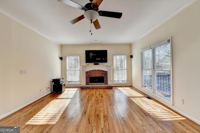 unfurnished living room with ceiling fan, a fireplace, wood-type flooring, and crown molding