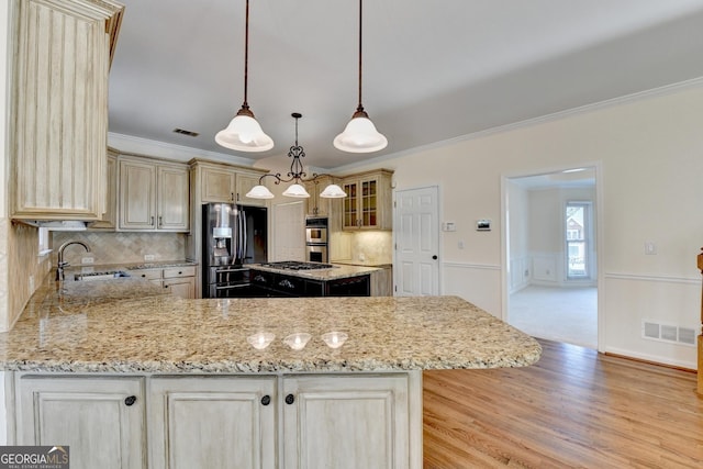 kitchen with sink, ornamental molding, stainless steel appliances, and tasteful backsplash