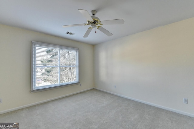 spare room with ceiling fan and light colored carpet