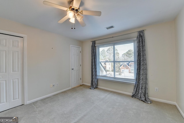 carpeted empty room featuring ceiling fan