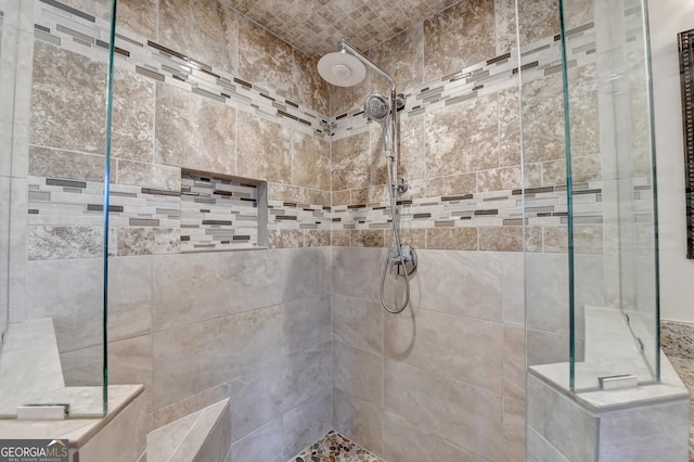 bathroom featuring a tile shower and brick ceiling