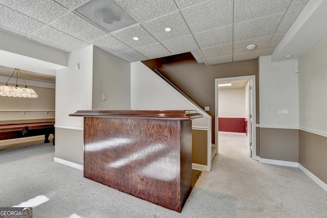 bar with a paneled ceiling and light carpet