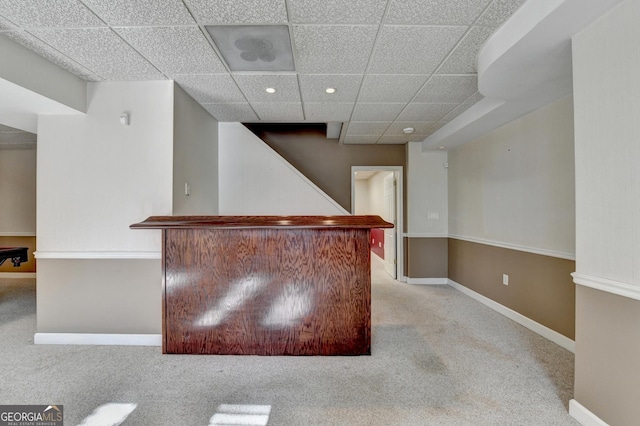 bar with a drop ceiling and light colored carpet