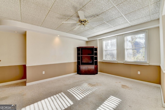 unfurnished room with ceiling fan, a drop ceiling, and carpet floors