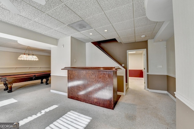 interior space with a paneled ceiling, decorative light fixtures, light carpet, and billiards