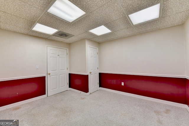 unfurnished room featuring a paneled ceiling and carpet floors