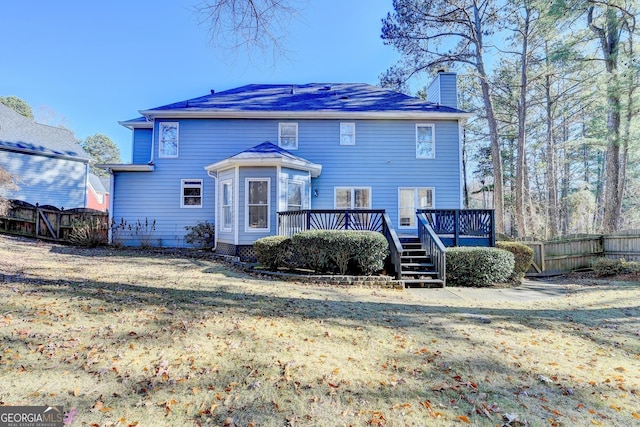 rear view of property with a wooden deck and a yard