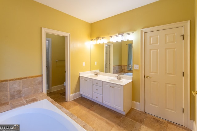 bathroom with vanity, toilet, and a tub