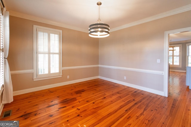 unfurnished room featuring crown molding, wood-type flooring, and a notable chandelier