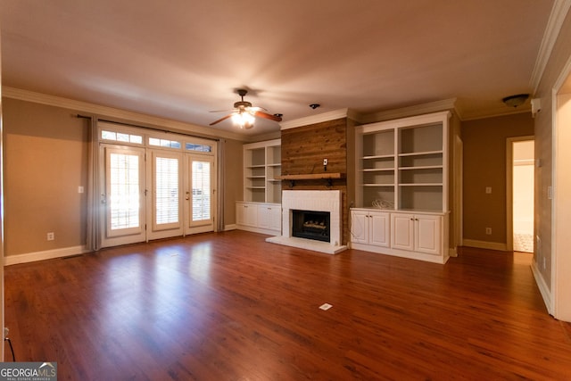 unfurnished living room with a brick fireplace, dark hardwood / wood-style floors, ceiling fan, built in shelves, and ornamental molding