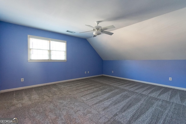 additional living space featuring dark colored carpet, ceiling fan, and lofted ceiling