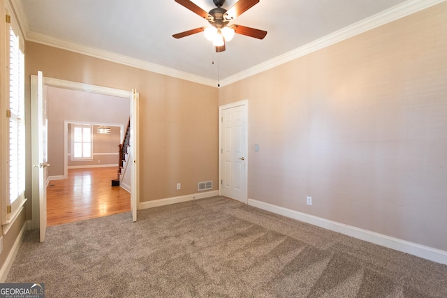 carpeted spare room featuring ceiling fan and ornamental molding