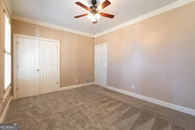 unfurnished bedroom featuring a closet, ceiling fan, crown molding, and carpet floors