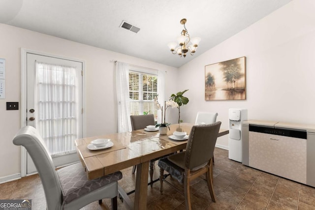 dining area with a chandelier and vaulted ceiling