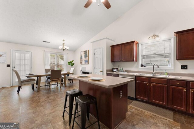 kitchen with a center island, lofted ceiling, ceiling fan with notable chandelier, sink, and stainless steel dishwasher