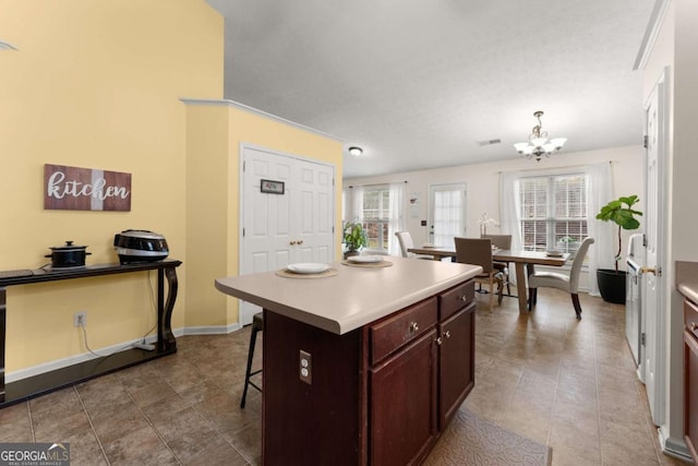 kitchen with a center island, plenty of natural light, a notable chandelier, and a breakfast bar area