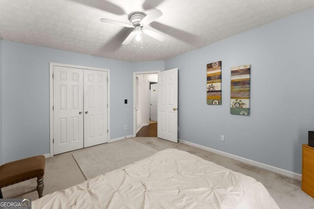 bedroom with light carpet, a textured ceiling, a closet, and ceiling fan