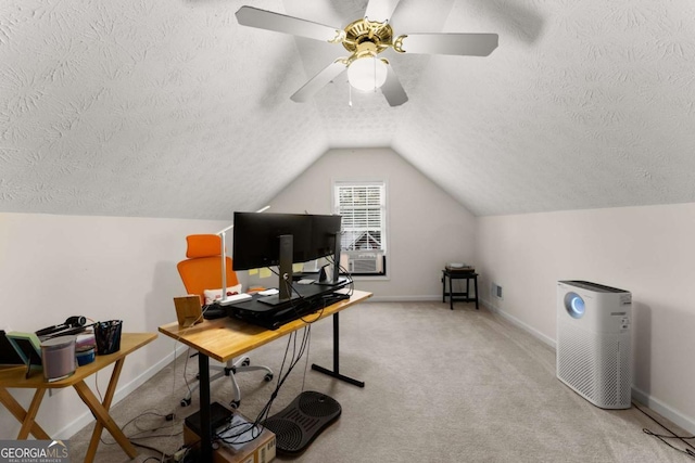 carpeted home office with vaulted ceiling, ceiling fan, and a textured ceiling