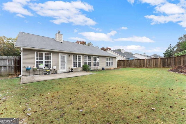 back of property with a lawn and a patio area