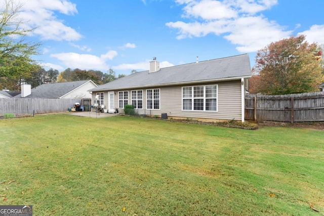 back of house featuring a lawn and a patio area