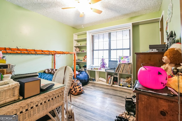 interior space with a textured ceiling, light hardwood / wood-style floors, and ceiling fan