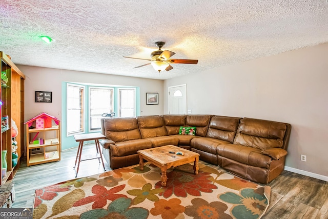 living room with hardwood / wood-style floors, a textured ceiling, and ceiling fan