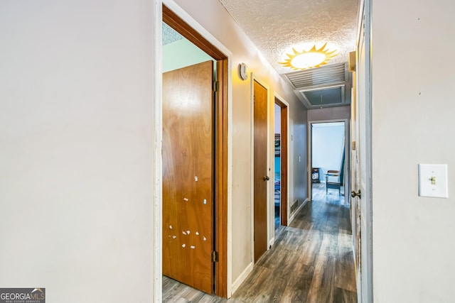 hallway featuring a textured ceiling and dark hardwood / wood-style flooring