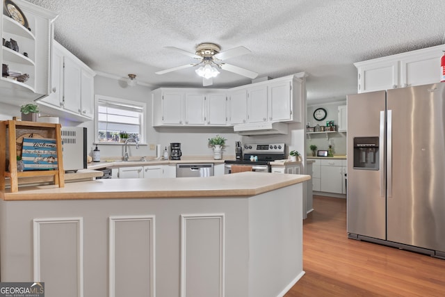 kitchen with kitchen peninsula, sink, light hardwood / wood-style floors, and appliances with stainless steel finishes