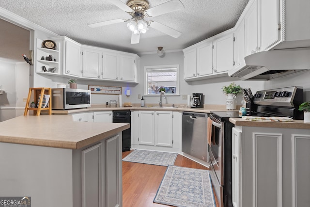 kitchen featuring stainless steel appliances, crown molding, light hardwood / wood-style floors, a textured ceiling, and white cabinets