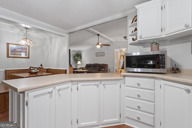 kitchen with kitchen peninsula, decorative light fixtures, white cabinets, and ceiling fan