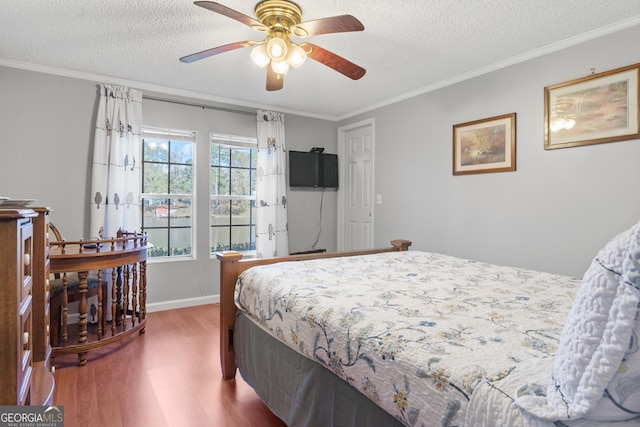 bedroom featuring hardwood / wood-style floors, a textured ceiling, ceiling fan, and crown molding