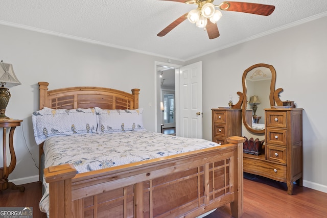 bedroom with hardwood / wood-style floors, a textured ceiling, ceiling fan, and ornamental molding