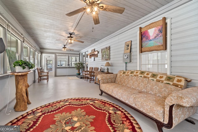 living room with concrete floors, ceiling fan, wooden ceiling, and wood walls