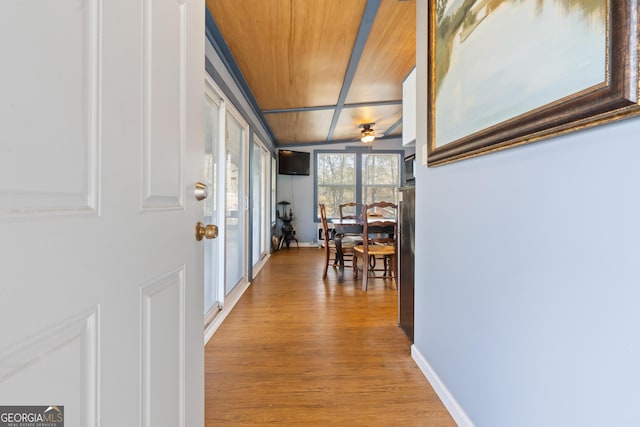 corridor with light wood-type flooring, lofted ceiling, and wood ceiling