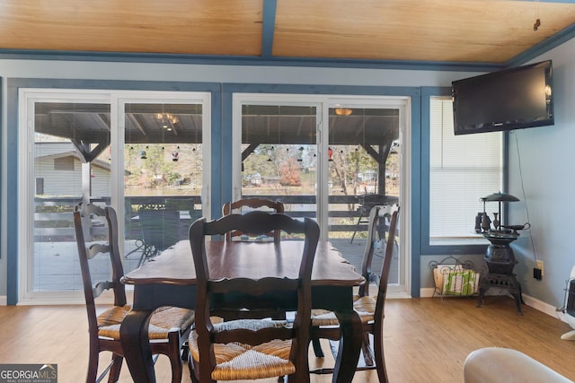 dining area featuring light hardwood / wood-style floors, wood ceiling, and ornamental molding