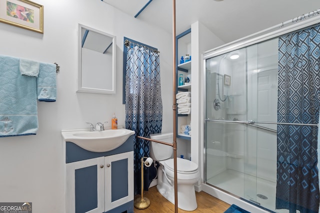 bathroom featuring hardwood / wood-style floors, vanity, toilet, and an enclosed shower