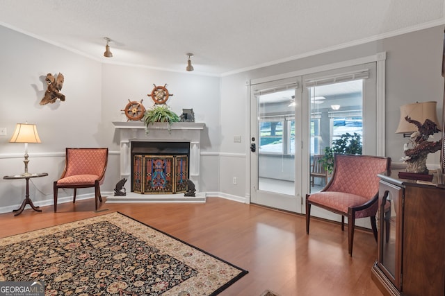 sitting room featuring hardwood / wood-style flooring and crown molding