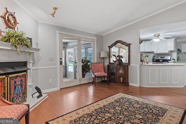 living room with ceiling fan, hardwood / wood-style floors, and ornamental molding