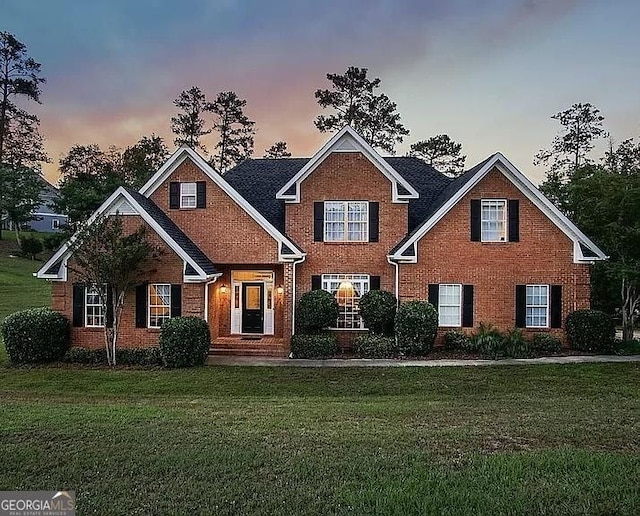 view of front of home featuring brick siding and a front lawn