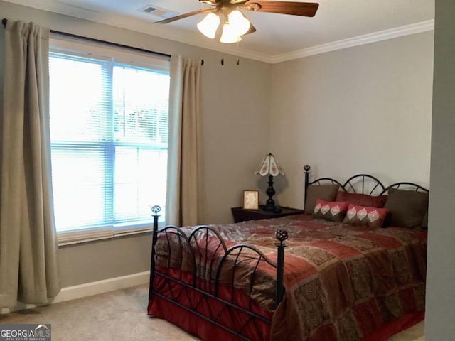 carpeted bedroom featuring ceiling fan and crown molding