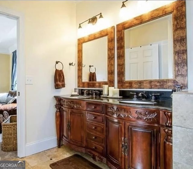 bathroom featuring double vanity, ensuite bathroom, baseboards, and tile patterned floors