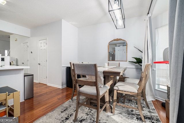 dining area with dark wood finished floors and baseboards