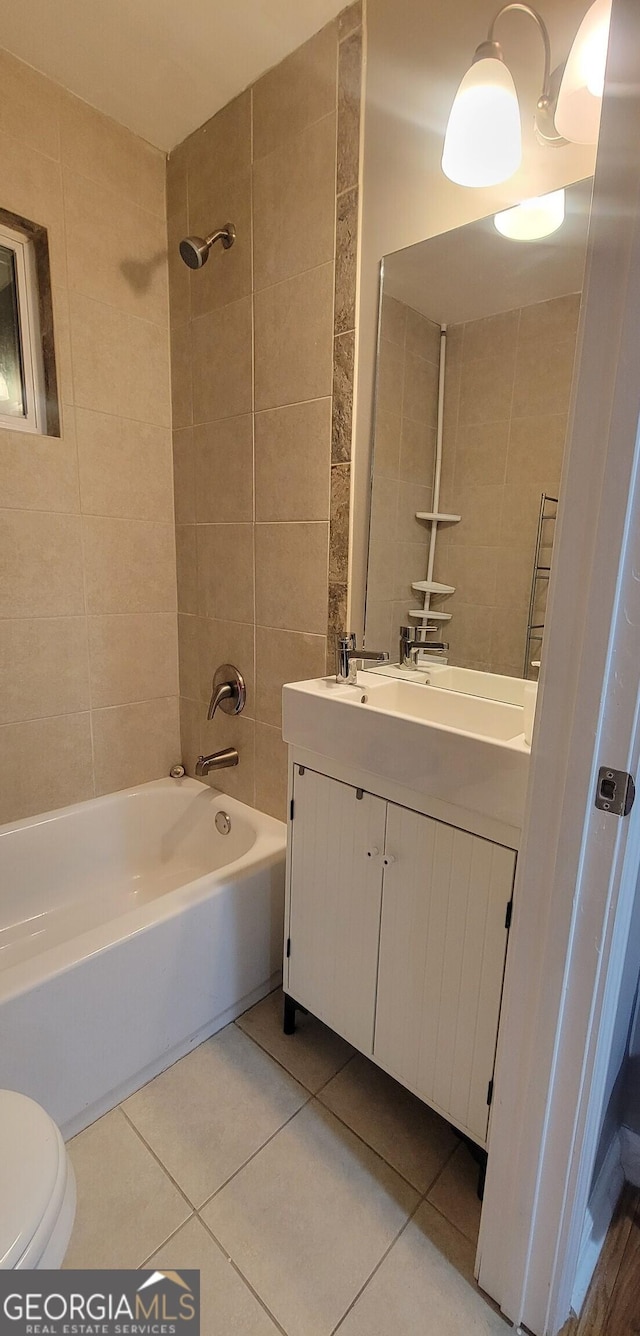 full bathroom featuring tile patterned floors, tiled shower / bath combo, toilet, and vanity