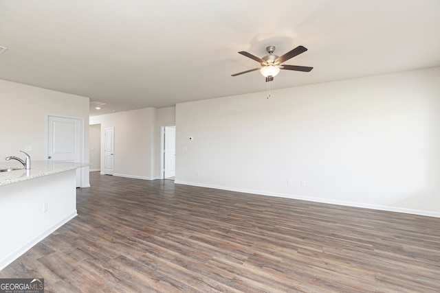 unfurnished living room with dark hardwood / wood-style flooring, ceiling fan, and sink