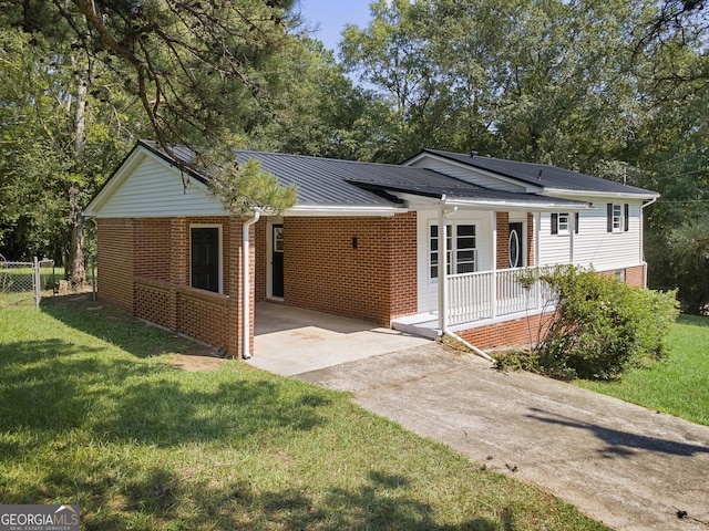 ranch-style home with covered porch, a front lawn, and a carport