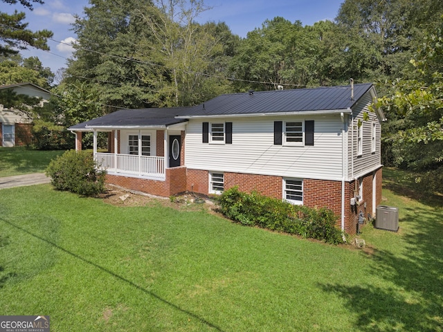 tri-level home with a porch, a front lawn, and cooling unit