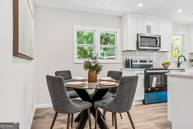 dining area with sink and light hardwood / wood-style floors