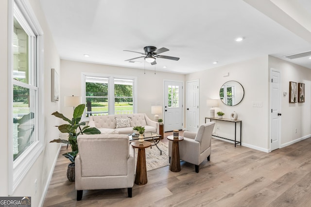 living room featuring ceiling fan and light hardwood / wood-style flooring